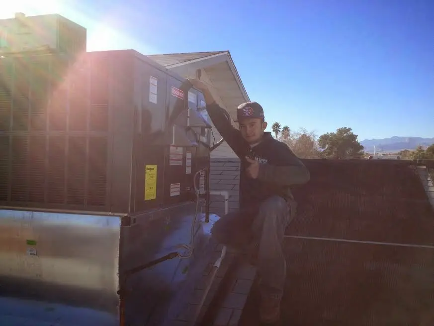 HVAC technician performing Heat Pump Repair on a rooftop unit in Redlands